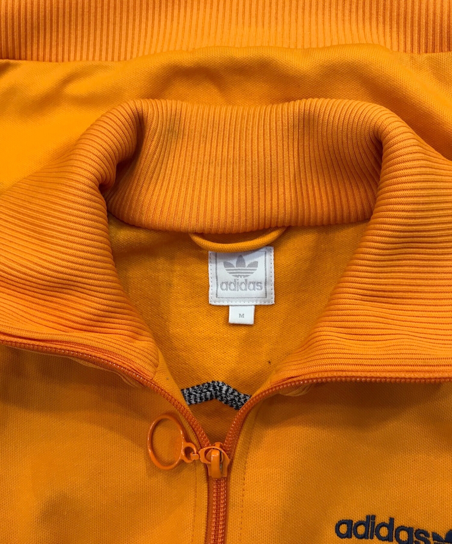 adidas (アディダス) クマ刺繍トラックジャケット オレンジ サイズ:M